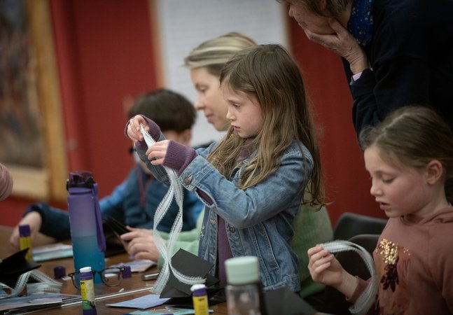 Adults and children taking part in a craft activity together.