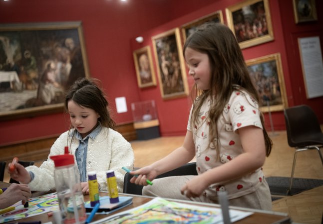 Two children taking part in a craft activity together.