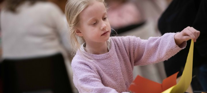 A girl with long blonde hair taking part in a craft activity