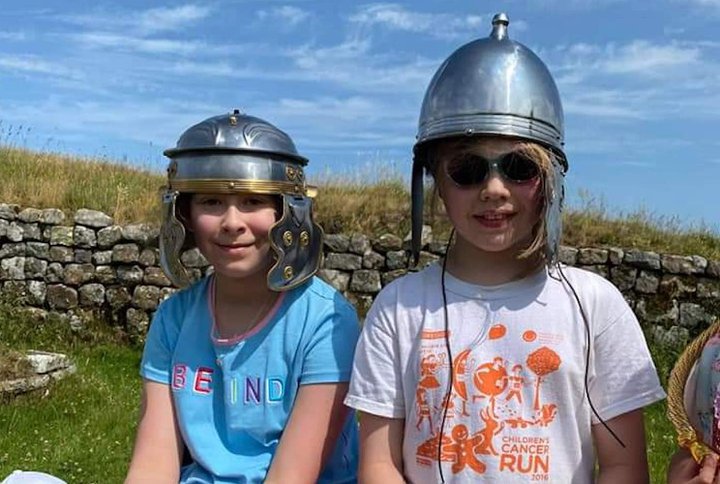 Children wearing Roman helmets.