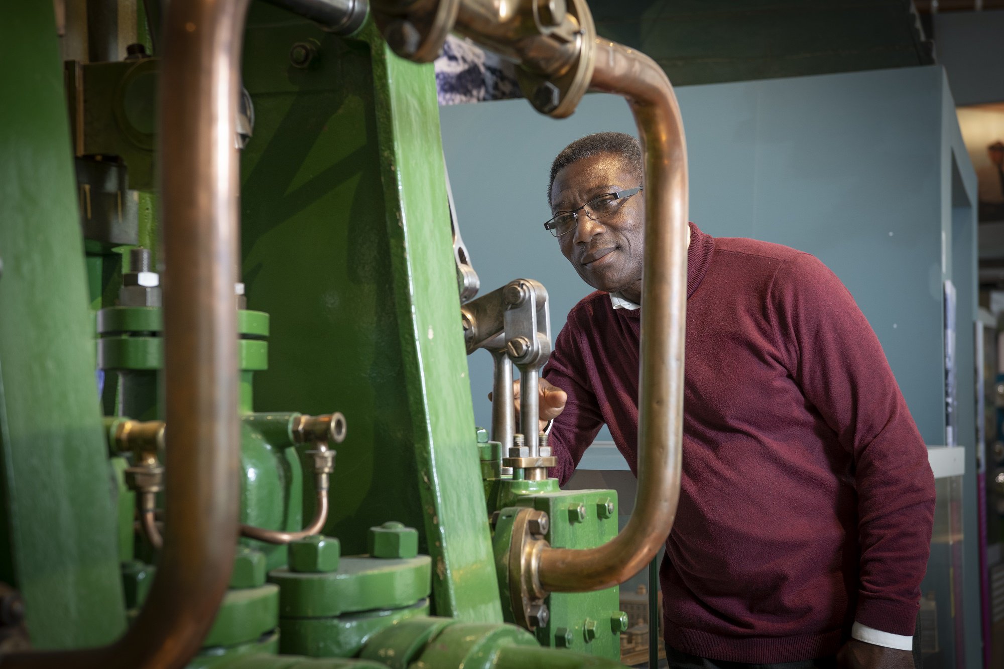 Man looking at industrial machinery in a museum.