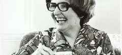 Dame Catherine Cookson laughs holding a cup of tea