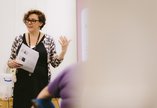 A woman talking to a group as part of a museum workshop.