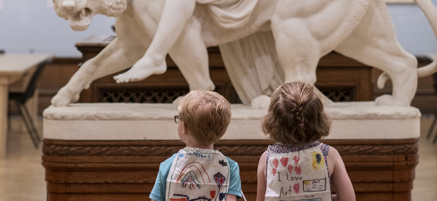 Photo of two children walking towards a lion sculpture in the Shipley.