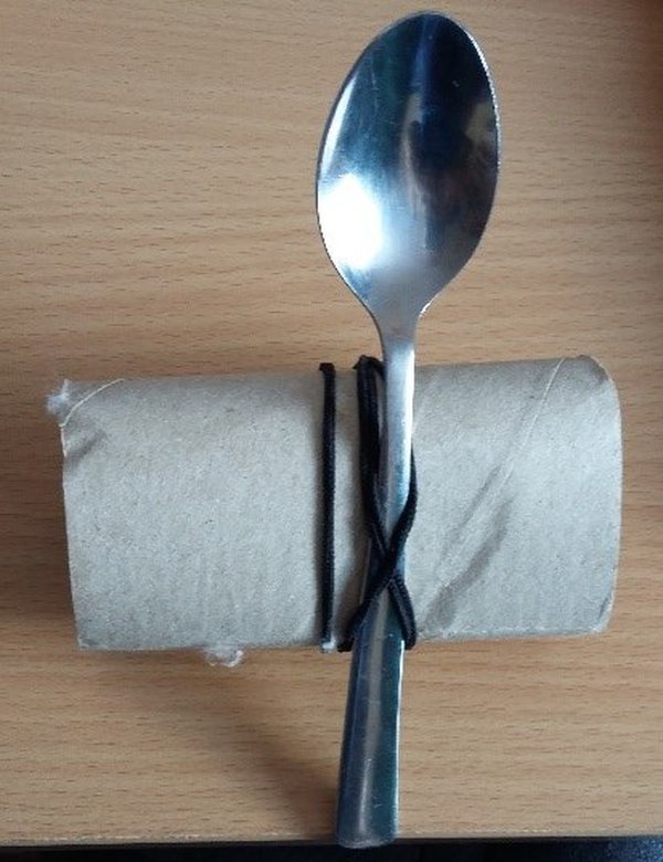 Spoon tied to cardboard tube