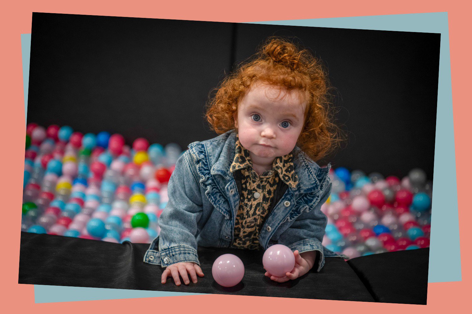 A child playing in a ball pool.