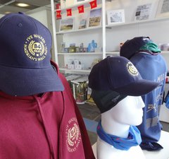 A selection of peaked caps and souvenir clothing