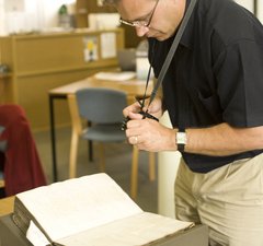 Man looking at volume in Archives
