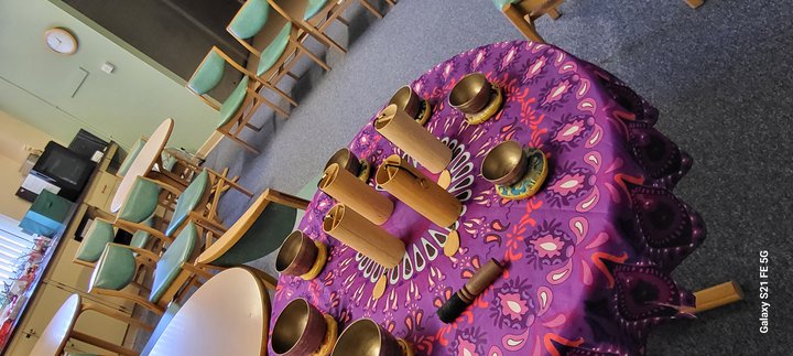Musical instruments laid on a purple and yellow cloth on a table.