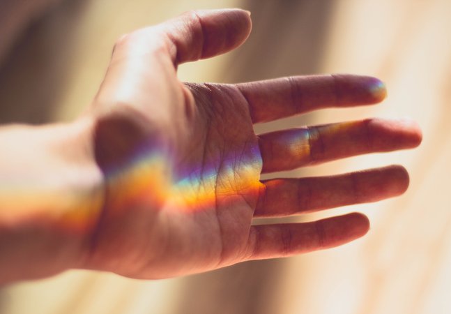 hand with rainbow light landing on the palm