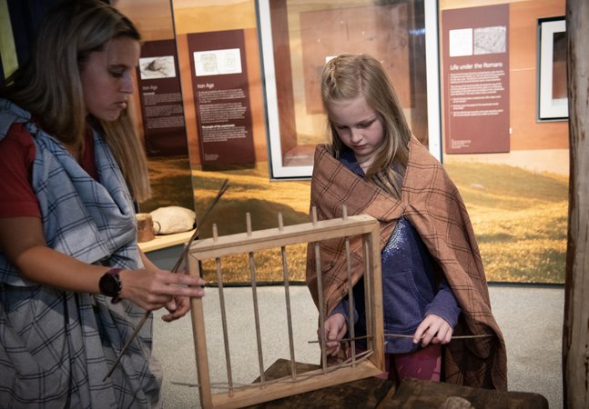 Woman and girl looking at model wattle fence