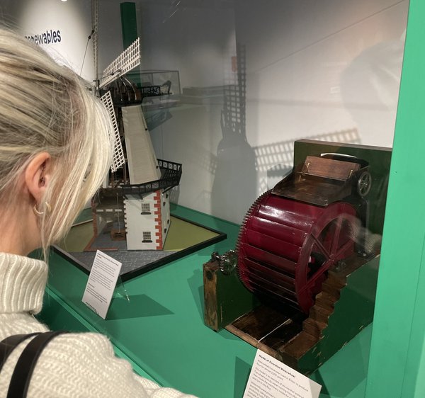 Visitor looks at water wheel object