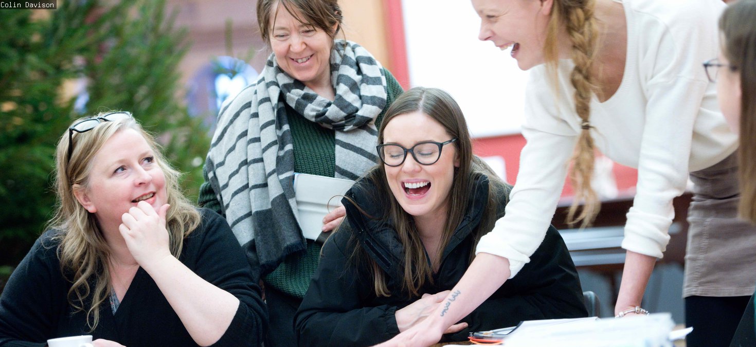Four people around a table, laughing