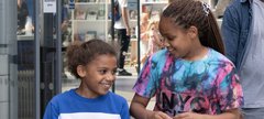 Two girls smile at each other Discovery Museum 