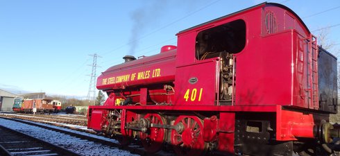 Red steam locomotive against blue sky and in snow