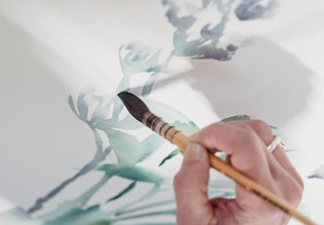 A hand painting a watercolour picture.