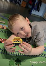 boy holds toy train in gallery