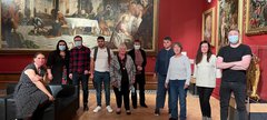 A group of people standing in the Shipley in front of the TInroetto painting