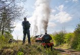 Steam train passing by visitors