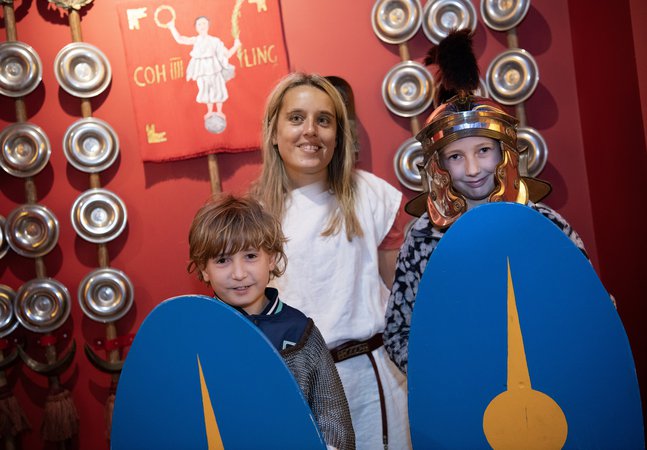 Two young children and an adult dressed as Romans
