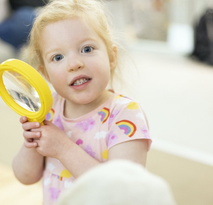 A young girl with a magnifying glass