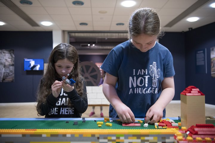Two young children playing with mini building bricks
