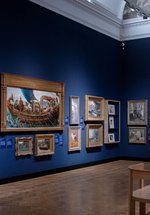 A photograph of the inside of an art gallery with oil paintings in gold frames.