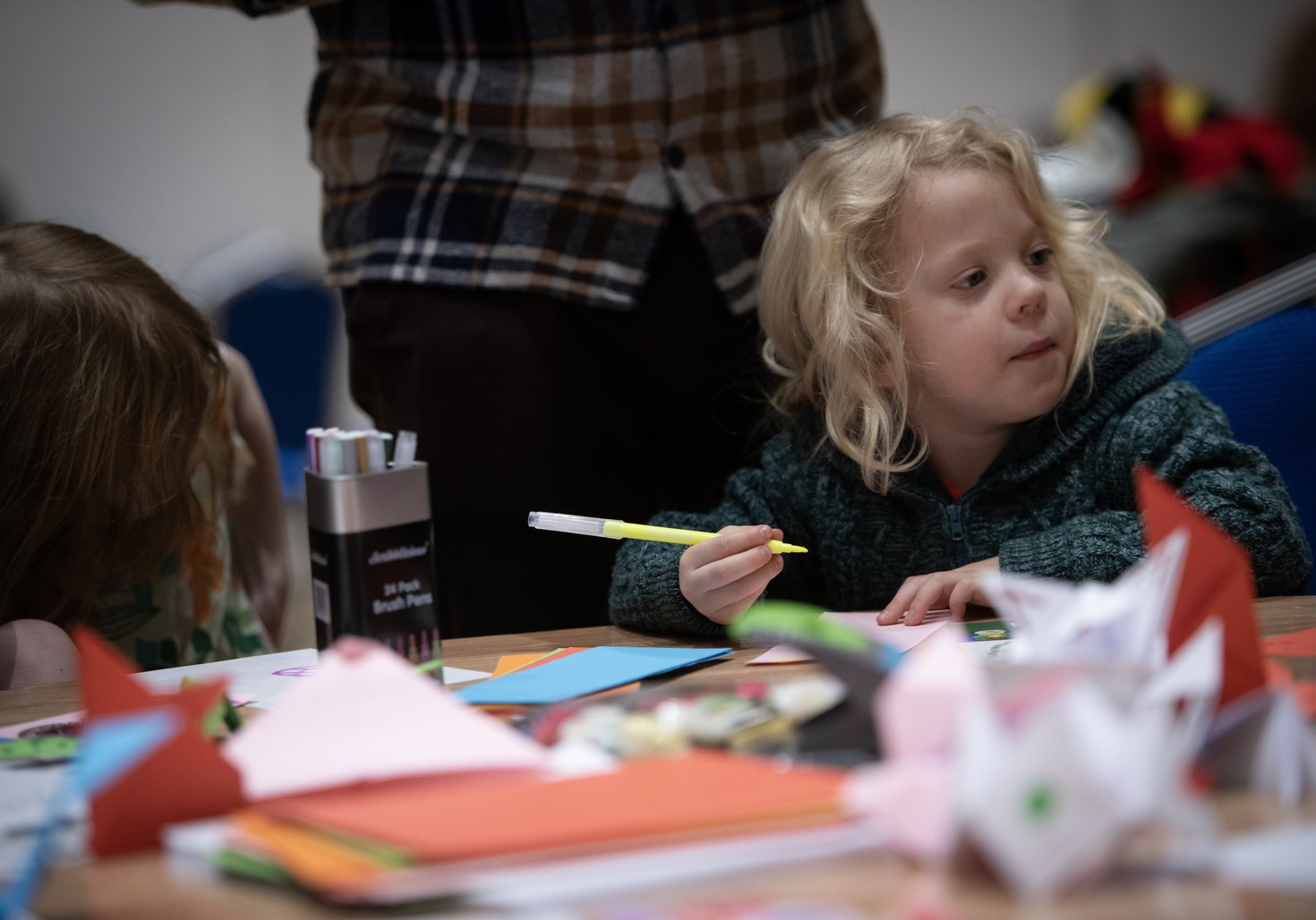 A young child holds a felt-tip. 