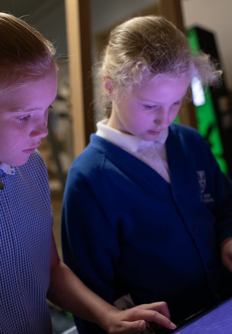 Two children looking at a interactive screen together.