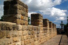 Modern reconstruction of Hadrian's Wall with Segedunum Roman Fort viewing tower in background