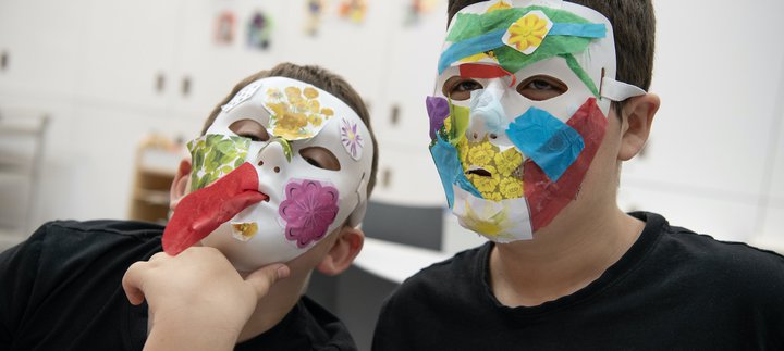 Two children are making masks.