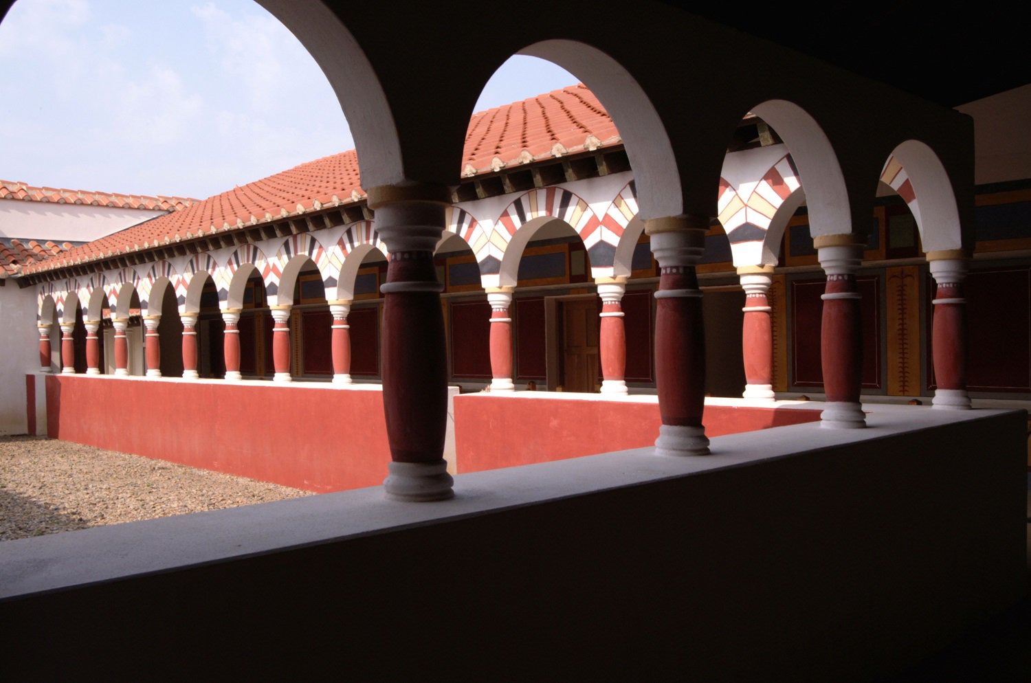 View of a Roman courtyard and arched pillars.