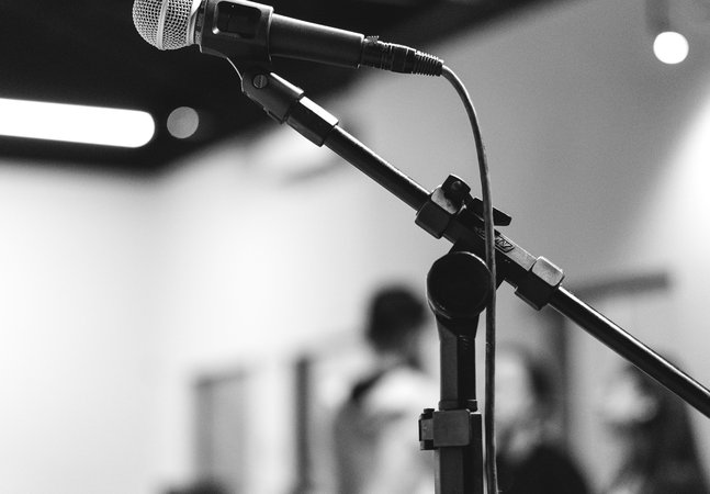 A black and white images of a microphone on a stand 