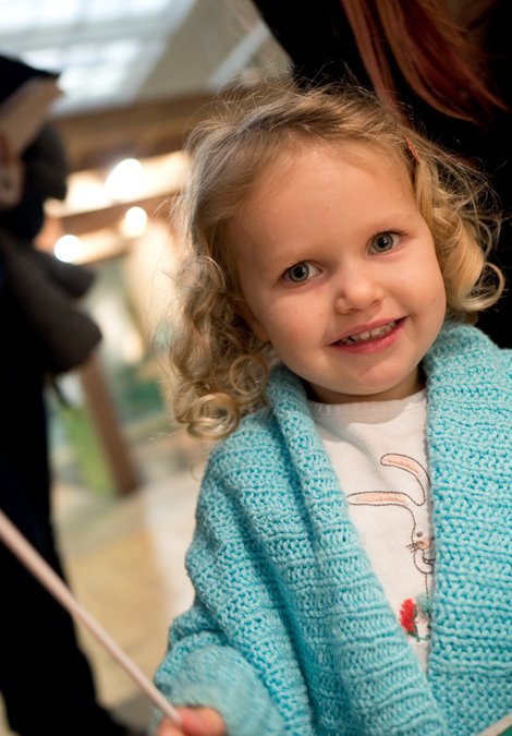 A young visitor to the Great North Museum holds a paper butterfly on a stick