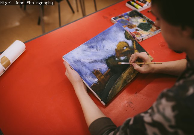 boy painting onto canvas