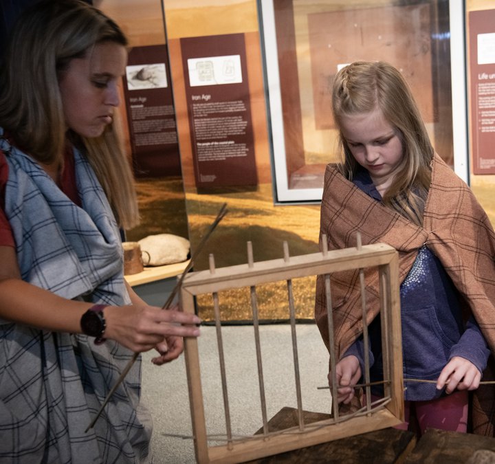 Woman and girl looking at model wattle fence