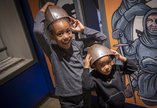 Two little girls try on armour in Newcastle Story 