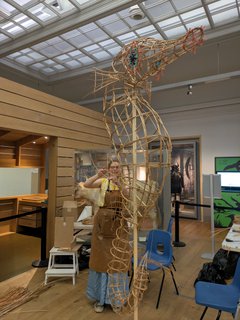 A large seahorse artwork frame is being made by an artist.