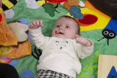 A baby is laying on a sensory mat.