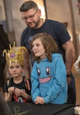 A family are listening to a curator talking about objects at the GNM:H