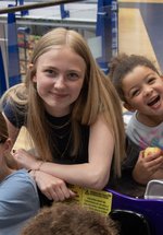 Three girls of various age sitting having fun in the museum 