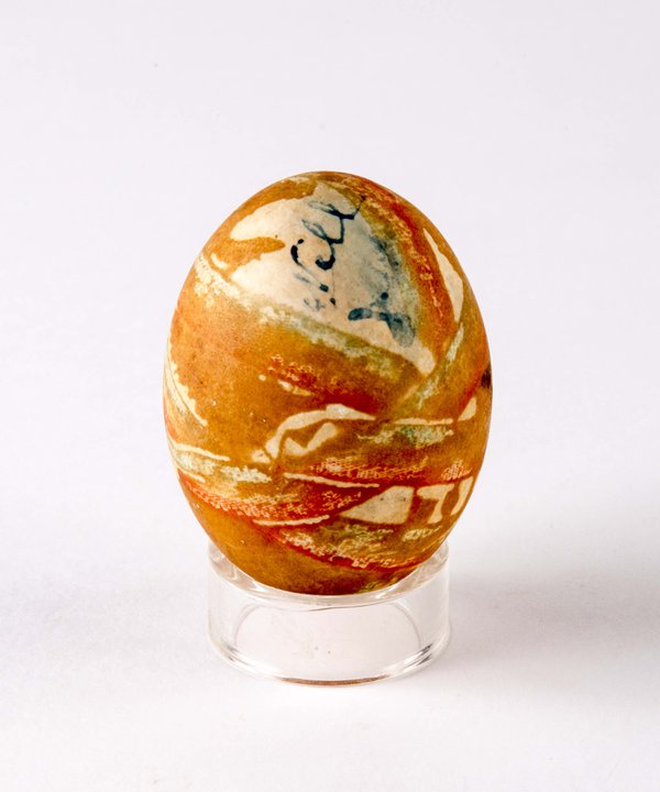 Decorated hen's egg, painted with orange and green patterns.