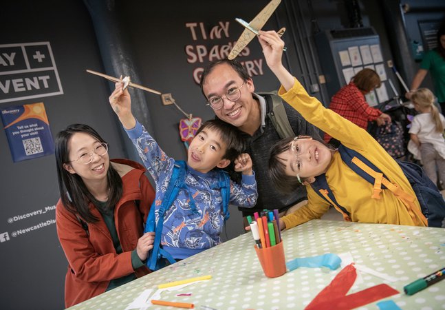 Family group with parents and two children smile at camera  