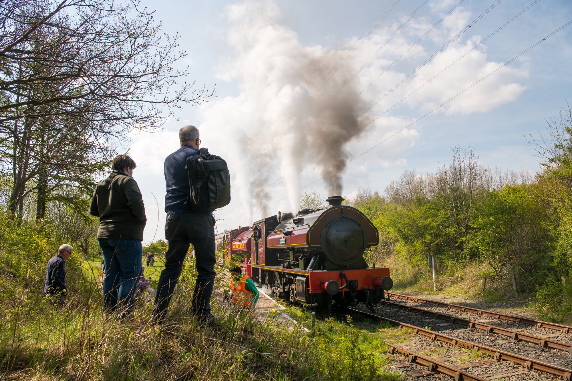 Onlookers watch a steam train go by at a heritage railway.