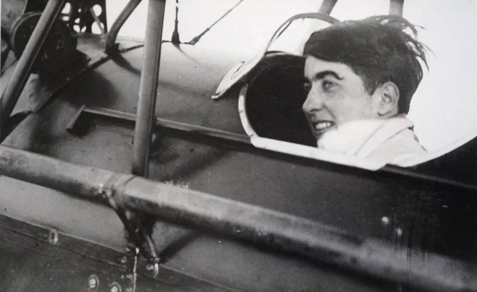 a picture of a woman with cropped hair in the pilot seat of a prop plane
