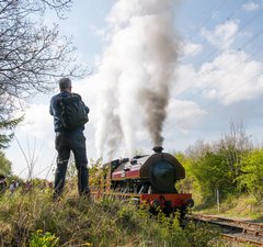 Steam train passing by visitors