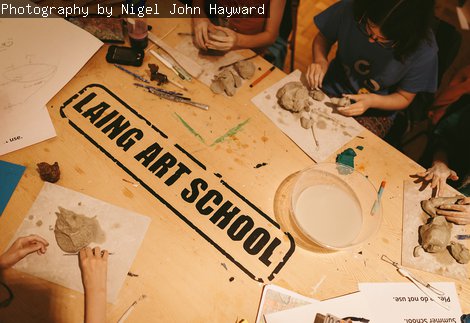 A photograph of a table with 'Laing Art School' printed on it