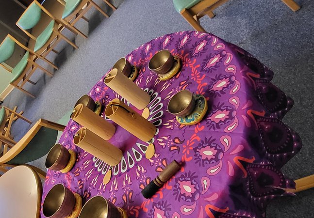 Musical instruments laid on a purple and yellow cloth on a table.