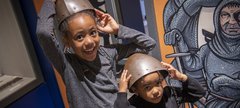 Two little girls try on armour in Newcastle Story 
