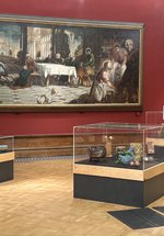Three glass display cases with ceramic objects in a art gallery.